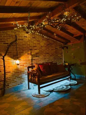 a couch in a room with a brick wall with lights at Bohemio Chic House - Alojamiento con vista al bosque a 45 minutos de Medellin en Santa Elena in Santa Elena