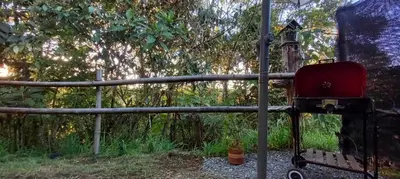 a red chair sitting next to a wooden fence at Bohemio Chic House - Alojamiento con vista al bosque a 45 minutos de Medellin en Santa Elena in Santa Elena
