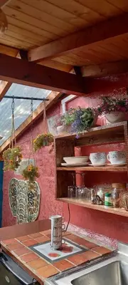 a kitchen with a counter with pots and pans at Bohemio Chic House - Alojamiento con vista al bosque a 45 minutos de Medellin en Santa Elena in Santa Elena