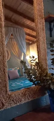 a mirror in a bedroom with a bed in a room at Bohemio Chic House - Alojamiento con vista al bosque a 45 minutos de Medellin en Santa Elena in Santa Elena