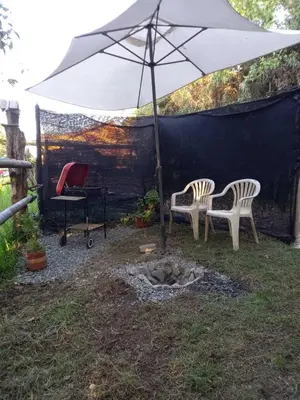 two chairs and an umbrella in a yard at Bohemio Chic House - Alojamiento con vista al bosque a 45 minutos de Medellin en Santa Elena in Santa Elena