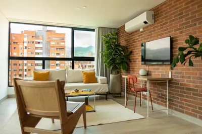 a living room with a couch and a brick wall at Nuevo y cálido Loft en Laureles in Medellín