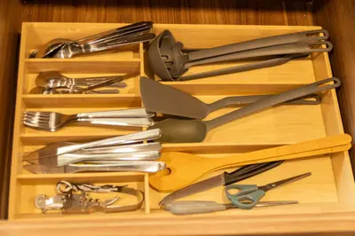 a wooden drawer filled with lots of kitchen utensils at Nuevo y cálido Loft en Laureles in Medellín