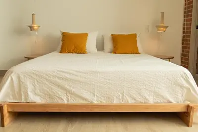 a bedroom with a large white bed with yellow pillows at Nuevo y cálido Loft en Laureles in Medellín