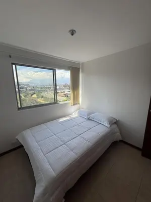 a bedroom with a large bed with a large window at Apartment in Poblado 17th Floor W Pool in Medellín