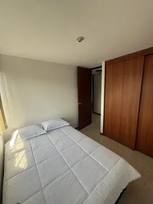 a bedroom with a large white bed and a wooden cabinet at Apartment in Poblado 17th Floor W Pool in Medellín