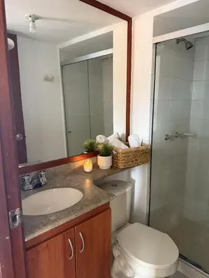 a bathroom with a sink and a toilet and a mirror at Apartment in Poblado 17th Floor W Pool in Medellín
