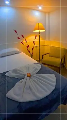 a bedroom with a bed with a flower on it at Hotel Marinilla Oriente in Marinilla