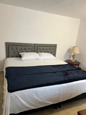 a bedroom with a large bed with a blue blanket at Hotel Marinilla Oriente in Marinilla