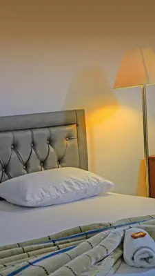 a close up of a bed with a pillow and a lamp at Hotel Marinilla Oriente in Marinilla
