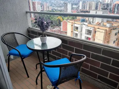 a table and two chairs on a balcony with a window at Confortable Apartamento, Sabaneta in Sabaneta