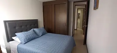 a bedroom with a bed with a blue comforter at Confortable Apartamento, Sabaneta in Sabaneta