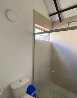 a bathroom with a toilet and a glass shower at Apartamento cómodo y tranquilo cerca al parque principal de Guatapé in Guatapé