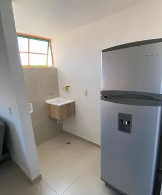 a small kitchen with a refrigerator and a sink at Apartamento cómodo y tranquilo cerca al parque principal de Guatapé in Guatapé