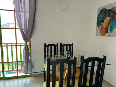 a dining room with a glass table and chairs at Apartamento cómodo y tranquilo cerca al parque principal de Guatapé in Guatapé