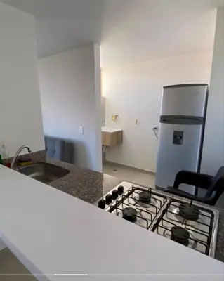 a kitchen with a stove and a refrigerator at Apartamento cómodo y tranquilo cerca al parque principal de Guatapé in Guatapé