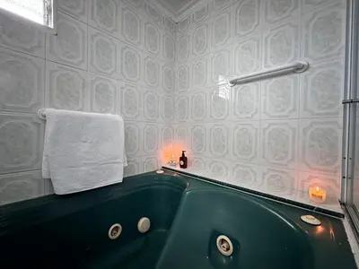 a bathroom with a green tub and a towel at Apartamento cerca a Estadio con balcon y 5 habitaciones in Medellín