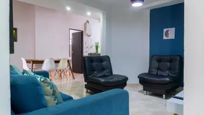 a living room with a blue couch and chairs at Apartamento cerca a Estadio con balcon y 5 habitaciones in Medellín