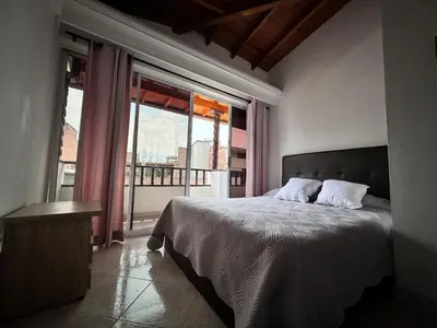 a bedroom with a bed and a large window at Apartamento cerca a Estadio con balcon y 5 habitaciones in Medellín