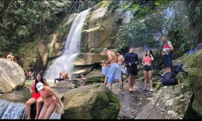 a group of people standing in front of a waterfall at Apartamento Vacacional in San Carlos Antioquia in San Carlos