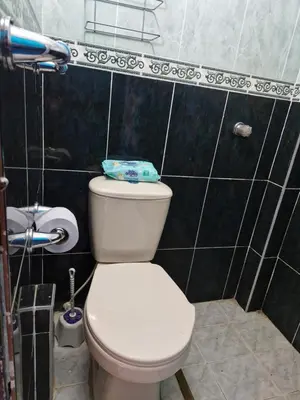 a bathroom with a white toilet and black tiles at Apartamento Vacacional in San Carlos Antioquia in San Carlos