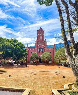 a large red building with a clock tower at Apartamento Vacacional in San Carlos Antioquia in San Carlos