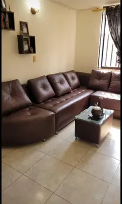 a brown leather couch in a living room with a table at Apartamento Vacacional in San Carlos Antioquia in San Carlos