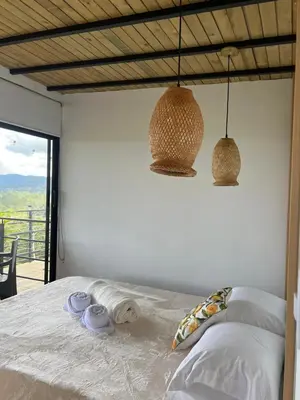 a bedroom with a bed with two towels and two lights at Althuum House in Chiquinquirá