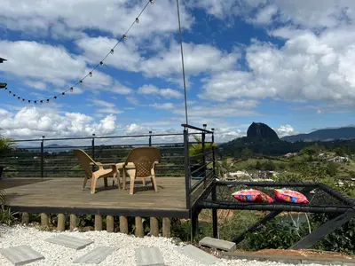 a table and chairs on a wooden deck with a view at Althuum House in Chiquinquirá