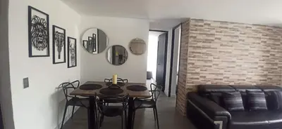 a living room with a table and a leather couch at Apartamento Las Vegas Plaza in Sabaneta