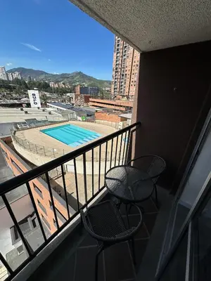 a balcony with a table and chairs and a pool at Apartamento Las Vegas Plaza in Sabaneta
