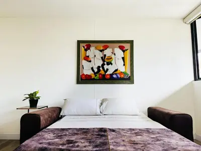 a bedroom with a bed and a painting on the wall at Amazing apartment in Poblado in Medellín