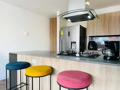 a kitchen with three colorful stools at a counter at Amazing apartment in Poblado in Medellín