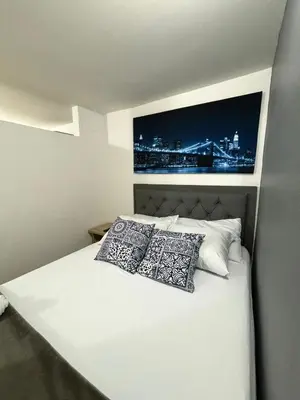a bedroom with a white bed with two pillows at Apartamentos Bello Antioquia in Bello
