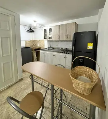 a kitchen with a table and a black refrigerator at Apartamentos Bello Antioquia in Bello
