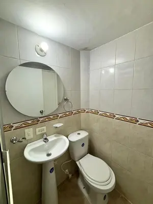 a bathroom with a toilet and a sink and a mirror at Apartamentos Bello Antioquia in Bello