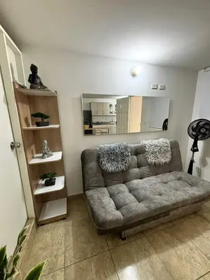 a living room with a couch and a large mirror at Apartamentos Bello Antioquia in Bello