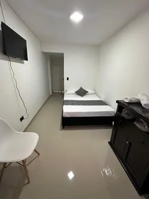 a bedroom with a bed and a chair in it at LA CASONA Finca Hostal in Apía