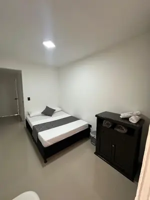 a bedroom with a bed and a table with a phone at LA CASONA Finca Hostal in Apía