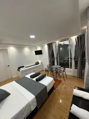 a bedroom with two beds and a table and chairs at LA CASONA Finca Hostal in Apía