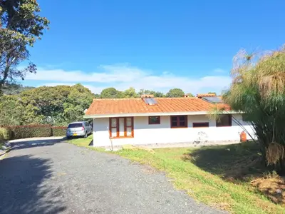 a white house with an orange roof on a road at Habitación en Casa San Miguel, Vereda El Plan, Santa Elena in Medellín