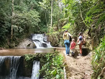 a group of people walking in front of a waterfall at Habitación en casa de campo via al aeropuerto in Copacabana