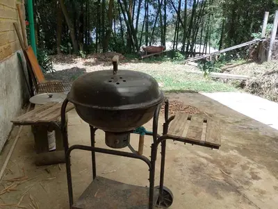 a grill sitting on a stand in a yard at Habitación en casa de campo via al aeropuerto in Copacabana