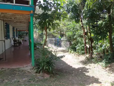 a porch of a house with a fence and trees at Habitación en casa de campo via al aeropuerto in Copacabana
