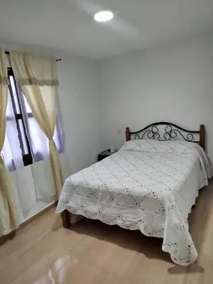 a bedroom with a bed with a white comforter at Hospedaje temporal in Carmen de Viboral