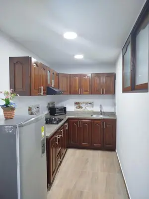 a kitchen with wooden cabinets and a white refrigerator at Hospedaje temporal in Carmen de Viboral