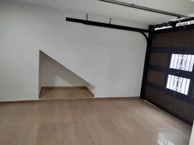 an empty room with a large white wall and a wooden floor at Hospedaje temporal in Carmen de Viboral