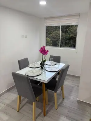 a dining room table with a vase of flowers on it at Apto nuevo, tranquilo y central in Manizales