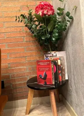 a table with a book on it next to a brick wall at Hermoso Loft in Medellín