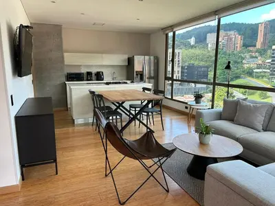 a kitchen and living room with a table and chairs at Great view 3 bedroom apartment near Provenza 1101 in Medellín